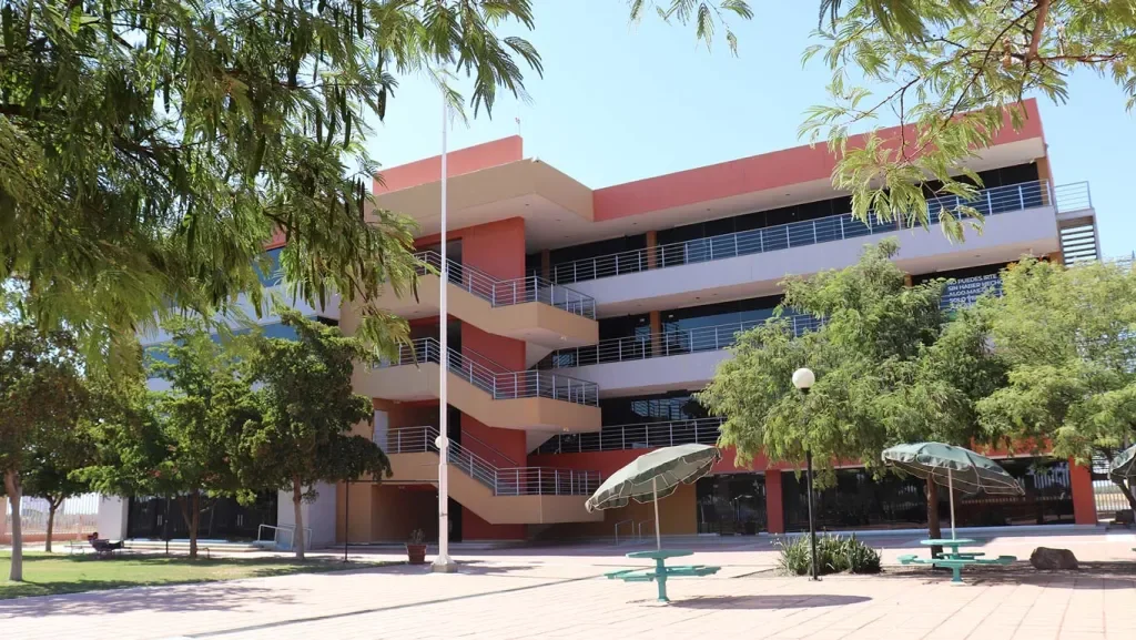 Edificio principal del campus con alumnos y estatua
