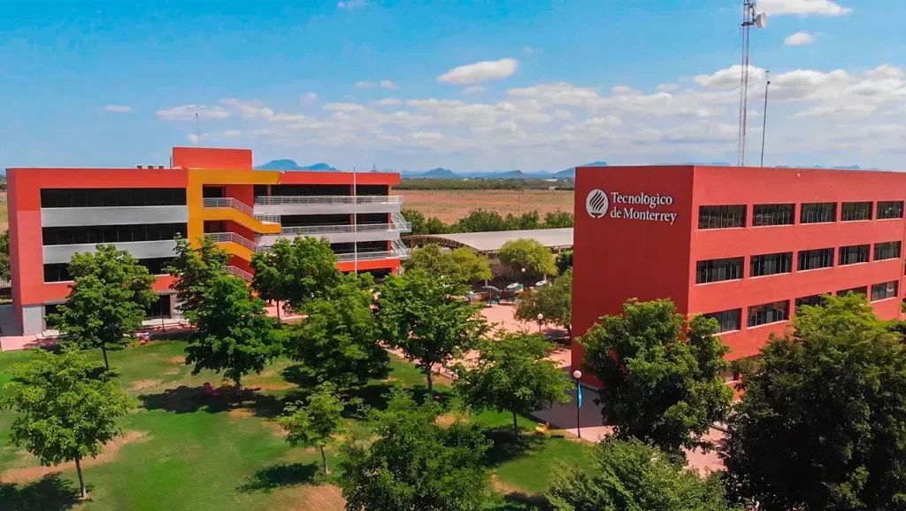 Campus Ciudad Obregón con alumnos, estatua y edificio al fondo